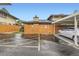Exterior view of parking area near buildings and wooden fence, featuring clearly marked spaces at 3827 S Fraser St, Aurora, CO 80014