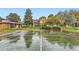 Community tennis court with green surface, trees, and nearby residential buildings at 3827 S Fraser St, Aurora, CO 80014