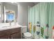 This bathroom features a light gray wall color, a surfboard shower curtain and a dark vanity at 13979 Night Owl Ln, Parker, CO 80134