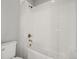 This bathroom features white tile, a bathtub with a shower and a toilet at 13979 Night Owl Ln, Parker, CO 80134