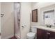 Bathroom featuring a tiled shower, toilet, vanity with a granite countertop, and storage cabinet at 13979 Night Owl Ln, Parker, CO 80134