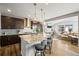 Open kitchen with island seating flows into a cozy living room with fireplace at 13979 Night Owl Ln, Parker, CO 80134