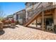 Paver patio with fire pit, hot tub, stairs to the home's deck, and comfortable seating at 13979 Night Owl Ln, Parker, CO 80134