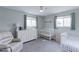 Inviting bedroom with a crib, reading chair and two windows allowing natural light at 2136 S Balsam Ct, Lakewood, CO 80227