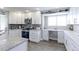 Bright, modern kitchen with white cabinets, granite countertops, stainless steel appliances, and ample workspace at 2136 S Balsam Ct, Lakewood, CO 80227