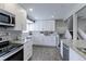 Modern kitchen showcasing granite countertops, white cabinetry, stainless steel appliances, and hardwood floors at 2136 S Balsam Ct, Lakewood, CO 80227