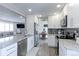 Stylish kitchen featuring granite countertops, white cabinetry, and stainless steel appliances with seamless living room access at 2136 S Balsam Ct, Lakewood, CO 80227
