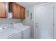 Convenient laundry room featuring wood cabinets and modern washer and dryer at 2136 S Balsam Ct, Lakewood, CO 80227
