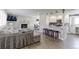 Open-concept living room with a fireplace, modern furnishings, and a breakfast bar leading to the kitchen at 2136 S Balsam Ct, Lakewood, CO 80227