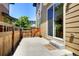 A back patio featuring a wooden fence, concrete foundation, and access to the house through a sliding door at 3450 Valentia St, Denver, CO 80238