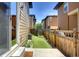 Backyard with synthetic turf and wooden fence. Patio access visible with sliding glass door and steps at 3450 Valentia St, Denver, CO 80238