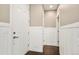Clean, white hallway with hardwood floors, modern baseboards, and neutral paint, leading to rooms at 3450 Valentia St, Denver, CO 80238
