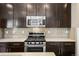 Well-equipped kitchen with stainless steel appliances, gas range, and elegant tile backsplash at 3450 Valentia St, Denver, CO 80238