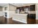 Modern kitchen featuring stainless steel appliances, dark cabinets, a center island, and granite countertops at 3450 Valentia St, Denver, CO 80238