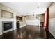 Open living space with fireplace, kitchen, and staircase, featuring hardwood floors at 3450 Valentia St, Denver, CO 80238