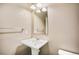 Well-lit powder room featuring a pedestal sink and rectangular mirror at 3450 Valentia St, Denver, CO 80238