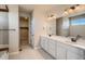 Bathroom featuring a double vanity with two sinks, a soaking tub, and a walk-in closet at 14120 Bunny Hop Ln, Parker, CO 80134