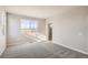 Bright main bedroom featuring neutral carpet, a window with a view, and an attached bathroom at 14120 Bunny Hop Ln, Parker, CO 80134