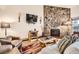 Living room features a stone fireplace, a leather chair, and modern decor at 325 Four O Clock Rd # 303, Breckenridge, CO 80424