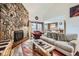 Bright living room featuring a stone fireplace and an open view to the kitchen and dining area at 325 Four O Clock Rd # 303, Breckenridge, CO 80424