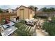 Backyard shed surrounded by building materials, overgrown vegetation, and assorted items at 14874 E 52Nd Ave, Denver, CO 80239