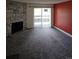 Carpeted living room features a stone fireplace and sliding glass door to the exterior at 7000 W 20Th Ave # 106, Lakewood, CO 80214