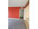 Cozy carpeted living room with a bright red accent wall and neutral color scheme at 7000 W 20Th Ave # 106, Lakewood, CO 80214