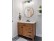 Bathroom boasts a wood vanity with marble countertop and a round mirror at 2506 16Th St, Denver, CO 80211