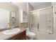 Neat bathroom featuring shower-tub combo with glass doors, vanity with sink and mirror at 8617 Gold Peak Dr # G, Highlands Ranch, CO 80130