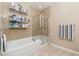 Well-lit bathroom featuring a bathtub, tiled shower, and shelving for storage at 8617 Gold Peak Dr # G, Highlands Ranch, CO 80130