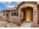 Inviting exterior with a vibrant yellow door, natural stone accents, and manicured landscaping at 8617 Gold Peak Dr # G, Highlands Ranch, CO 80130