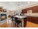 Modern kitchen with dark wood cabinets, a breakfast bar, and adjacent dining area with fireplace at 8617 Gold Peak Dr # G, Highlands Ranch, CO 80130