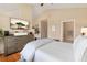 Spacious main bedroom has a high ceiling, television, dresser, and doorway to bathroom at 8617 Gold Peak Dr # G, Highlands Ranch, CO 80130