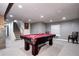 Basement featuring a billiards table with seating, and stairs in the background at 3889 S Fraser St, Aurora, CO 80014