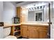 Cozy bathroom with oak cabinets, framed mirror, and decorative lighting at 3889 S Fraser St, Aurora, CO 80014