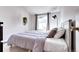 Bedroom featuring a bed, throw pillows, side table, hanging plants, and soft window lighting at 3889 S Fraser St, Aurora, CO 80014
