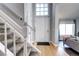 Bright entryway with hardwood floors, white staircase, and direct access to the living area at 3889 S Fraser St, Aurora, CO 80014