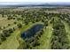 Aerial view showcasing the lush green golf course with mature trees and a serene pond at 3889 S Fraser St, Aurora, CO 80014