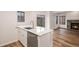 Open kitchen with white cabinets, stainless steel dishwasher, marble counter, and view to the fireplace at 2685 S Dayton Way # 234, Denver, CO 80231
