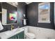 Stylish powder room featuring dark walls, decorative mirror, and modern fixtures at 9342 Bear River St, Littleton, CO 80125