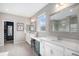 Bright primary bath with double sinks, vanity area, large mirrors, and a glass-enclosed shower at 9342 Bear River St, Littleton, CO 80125