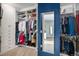 Walk-in closet with shelves and racks for optimal storage plus a view to the bath at 9342 Bear River St, Littleton, CO 80125