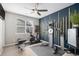 Exercise room with work-out equipment, TV, blue accent wall, and ceiling fan at 9342 Bear River St, Littleton, CO 80125