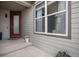 Inviting front porch with a vibrant red door, large window, and decorative flower pots at 9342 Bear River St, Littleton, CO 80125