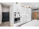Chic kitchen featuring white cabinets and marble backsplash, complemented by stainless steel appliances at 9342 Bear River St, Littleton, CO 80125