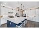 Modern kitchen boasts stainless steel appliances, white cabinets, and a large center island with seating at 9342 Bear River St, Littleton, CO 80125