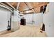 Unfinished basement with light wood flooring, utility connections and open ceiling at 7831 Hollywood St, Commerce City, CO 80022