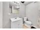Modest bathroom with a white vanity, framed mirror, and toilet in a gray interior at 7831 Hollywood St, Commerce City, CO 80022