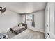 Small bedroom with a lounge chair and a window with soft natural lighting at 7831 Hollywood St, Commerce City, CO 80022