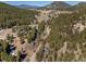 Aerial view shows home surrounded by trees and winding roads at 10179 S Turkey Creek Rd, Morrison, CO 80465